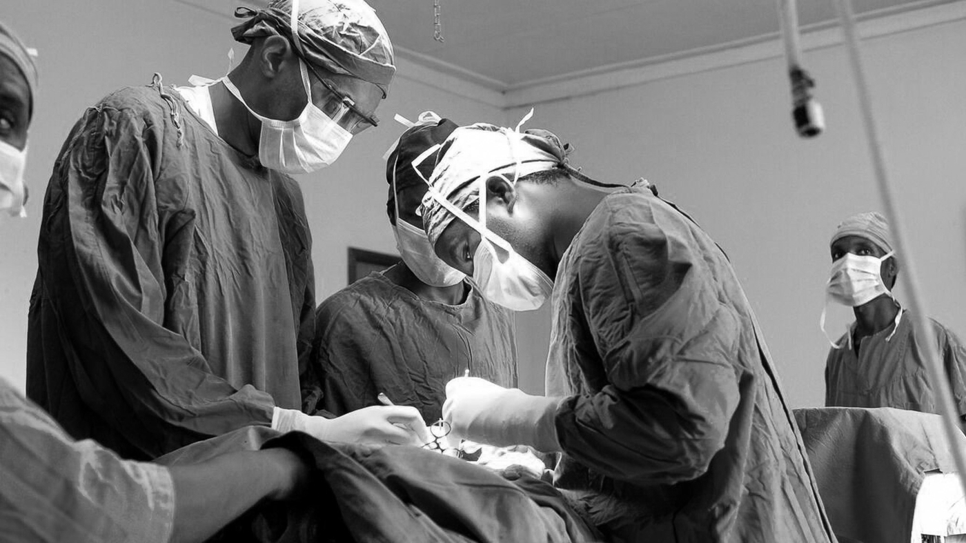 doctors doing operation in operating room greyscale