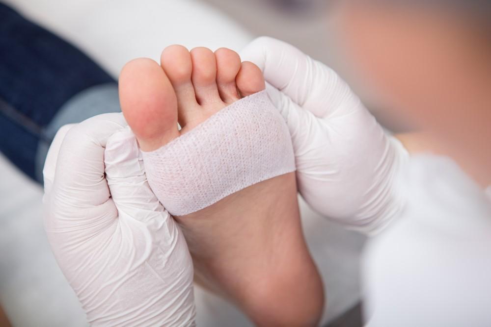 a person putting a bandage on a foot