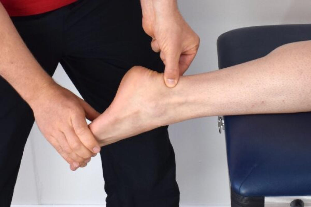 man holding a patient's tendon