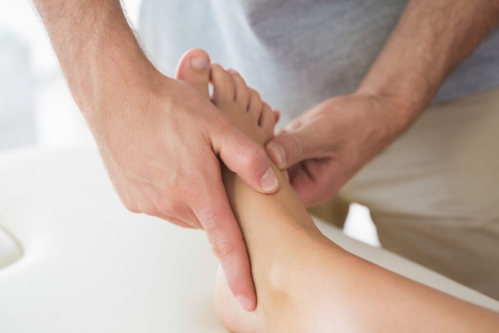 A doctor examines his patients' feet.