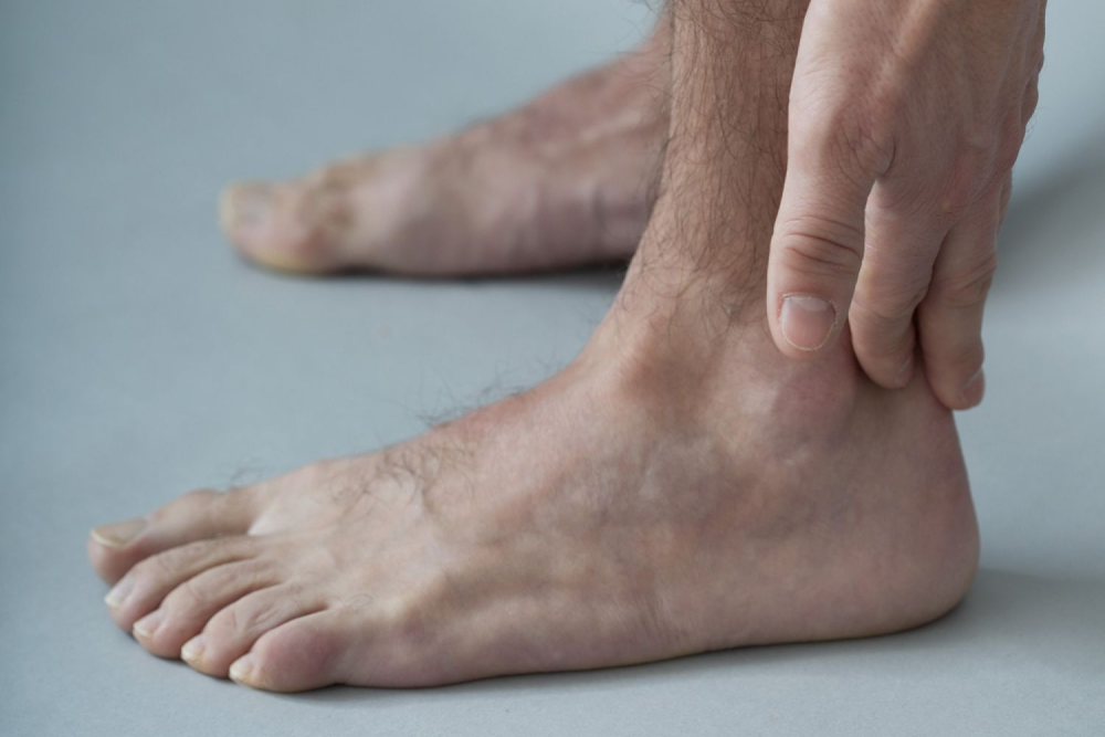 man holding his foot tendon