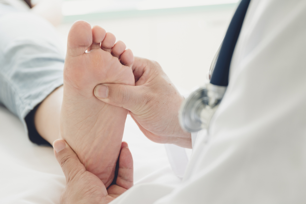 doctor pressing a male's foot